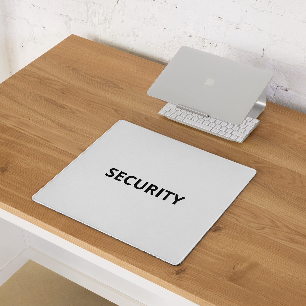 White SECURITY mouse pad shown on a wooden desk beside notebooks.